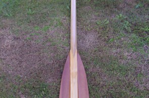 Single custom Greenland paddle made of Western Red Cedar with laminated shaft on display.