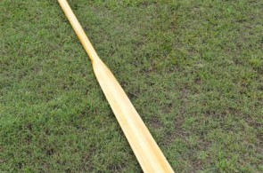 Single custom Greenland paddle made of Western Red Cedar with laminated shaft on display.
